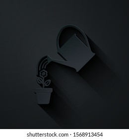 Paper cut Watering can sprays water drops above flower in pot icon isolated on black background. Irrigation symbol. Paper art style. Vector Illustration