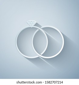 Paper cut Wedding rings icon isolated on grey background. Bride and groom jewelery sign. Marriage icon. Diamond ring. Paper art style. Vector Illustration