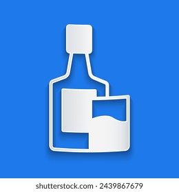 Paper cut Whiskey bottle and glass icon isolated on blue background. Paper art style. Vector