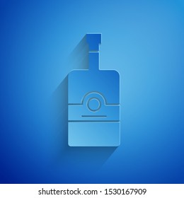 Paper cut Whiskey bottle icon isolated on blue background. Paper art style. Vector Illustration
