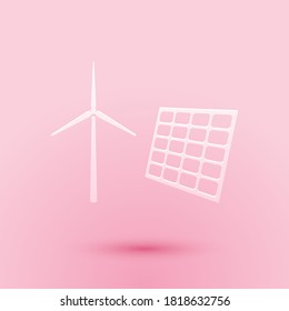 Paper cut Wind mill turbines generating electricity and solar panel icon isolated on pink background. Energy alternative, concept of renewable energy. Paper art style. Vector.