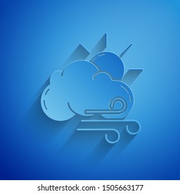 Paper cut Windy weather icon isolated on blue background. Sun with cloud and wind. Paper art style. Vector Illustration