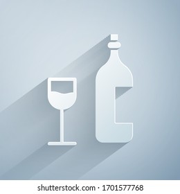 Paper cut Wine bottle with wine glass icon isolated on grey background. Happy Easter. Paper art style. Vector Illustration