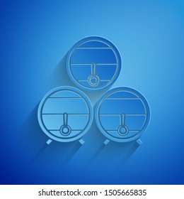 Paper cut Wooden barrel on rack with stopcock icon isolated on blue background. Paper art style. Vector Illustration