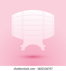 Paper cut Wooden barrel on rack icon isolated on pink background. Paper art style. Vector.