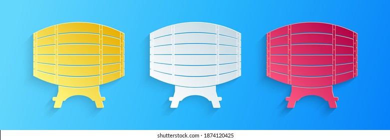 Paper cut Wooden barrel on rack icon isolated on blue background. Paper art style. Vector.