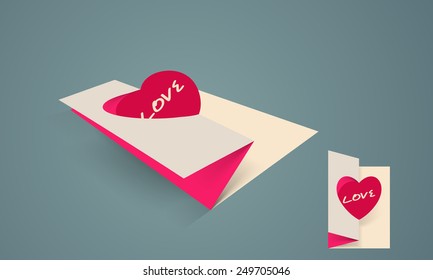 Paper folded card with pink heart and text Love for Happy Valentine's Day celebration.