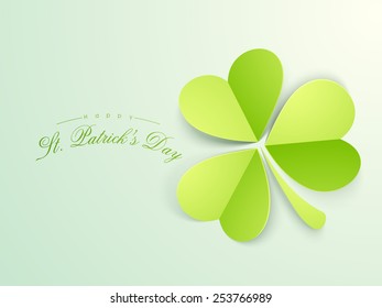 Paper folded glossy shamrock leaf on green background for Happy St. Patrick's Day celebration.