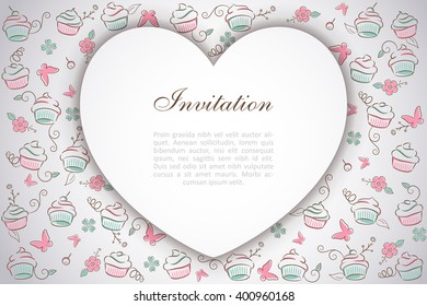 Paper heart over a background pattern of sweet cupcakes drawn