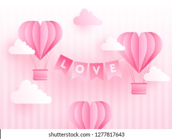 Paper origami of heart shapes hot air balloons with love lettering on cloudy stripe background. Valentine's Day celebration poster or template design.