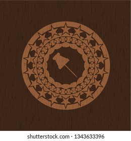 paper pin icon inside badge with wood background
