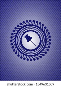 paper pin icon inside badge with denim background