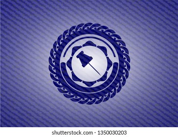 paper pin icon inside badge with denim background