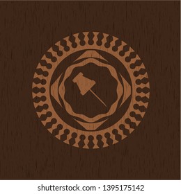 paper pin icon inside badge with wood background