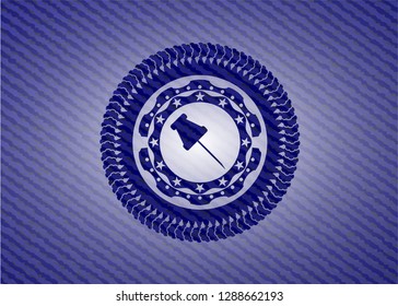 paper pin icon inside emblem with denim texture