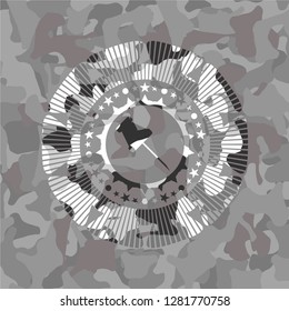 paper pin icon inside grey camouflage emblem