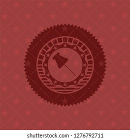 paper pin icon inside red emblem