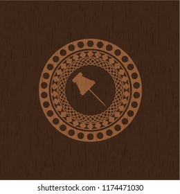 paper pin icon inside wooden emblem