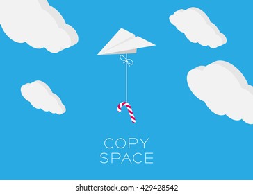 Paper plane hanging walking stick candy flying in the blue sky and cloud background with copy space, postcard size 5x7 inches