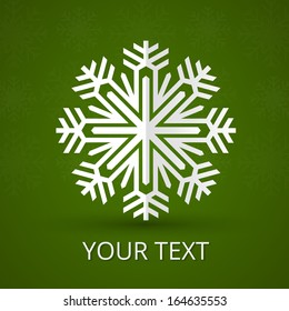Paper snowflake on green background with copy space
