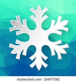 Paper snowflake over abstract geometric background consisting of colored triangles.