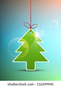 Paper vector green christmas tree hanging by a thread with lens flare effect.