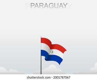 La bandera paraguaya ondea sobre un polo alto bajo un cielo blanco