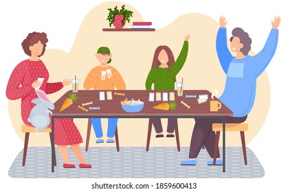 Parents and children spending time together. Kids joyfully raise hands. People are playing board game. Family sitting in an apartment with cards in their hands. Rabbit climbs on the table for a carrot