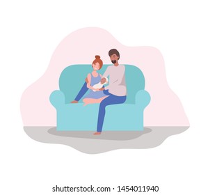parents taking care of newborn baby in the couch