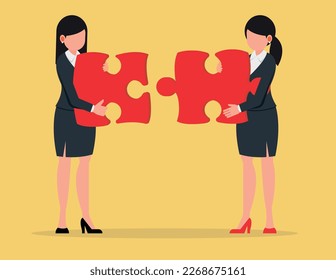 Partnership or teamwork. Two business women joining together large jigsaw puzzle pieces.