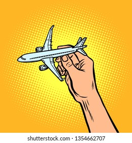 passenger plane in hand. metaphor of travel and tourism. Comic cartoon pop art vector retro vintage drawing