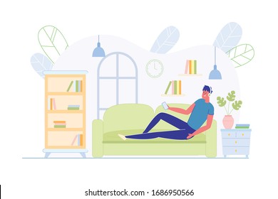 Passive Rest at Home on Couch after Hard Day. Guy at Home Resting on Sofa, Listening to Music through Headphones and Watching Something on Smartphone. At Home he Relax, there are Many Books around.