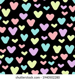 Pastel vector doodled hearts seamless repeat pattern with black background.