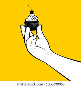 Pastry cook holding cupcake