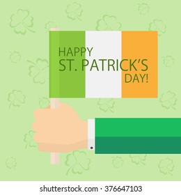 Patrick's day theme with the flag of Ireland in hand on green background with clovers, illustration.