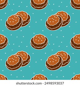 Pattern of cookies with white icing, sprinkled with sesame seeds, on blue background.