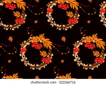 The pattern in the form of a circle formed by the branches and berries of rowan. The pattern in the autumn style on a black background. Also on the background can be seen maple leaves.