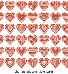 Pattern with gingerbread hearts. Cute Christmas background with hand drawn cookies. Seamless winter pattern. Brown colors.