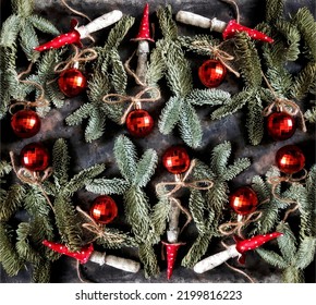 A pattern of handmade fly agarics and christmas balls with nobilis fir branches on black concrete background. Beautiful background of clay toadstools. Christmas concept.
