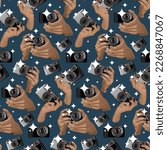 A pattern with a retro camera in his hands with a flash on a blue background. Brown-gray camera in the replay. Background for printing on textiles and paper. Retro-themed with camera and hands