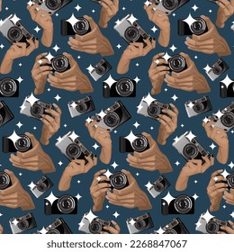 A pattern with a retro camera in his hands with a flash on a blue background. Brown-gray camera in the replay. Background for printing on textiles and paper. Retro-themed with camera and hands