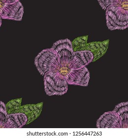 Pattern of violet flower for seamless embroidery. Colored stitches on a black background. Smooth violet and green colors pattern for hand made embroidery.