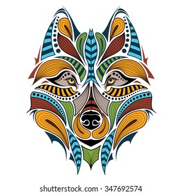 Patterned colored head of the wolf. African / indian / totem / tattoo design. It may be used for design of a t-shirt, bag, postcard and poster.