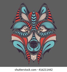 Patterned colored head of the wolf. African / indian / totem / tattoo design. It may be used for design of a t-shirt, bag, postcard and poster.