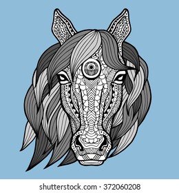 Patterned head of the horse on the blue background. African, indian design. It may be used for design of a t-shirt, bag, postcard, a poster and so on. Vector. Horse white black colors painted by hand.
