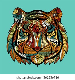 Patterned tiger head on a blue background. Abstract ethnic picture tiger head with an unusual ornament. Multi-colored ornament painted by hand. Vector. 