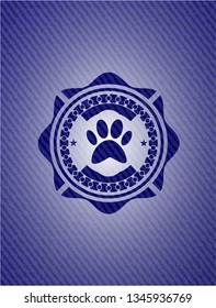 paw icon inside badge with denim texture