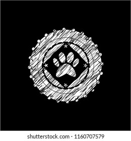paw icon inside chalkboard emblem written on a blackboard