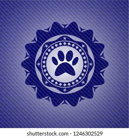 paw icon inside emblem with denim texture