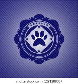 paw icon inside emblem with denim texture